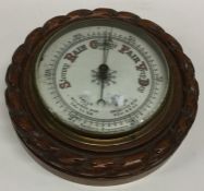 A small oak Aneroid barometer. Est. £20 - £30.