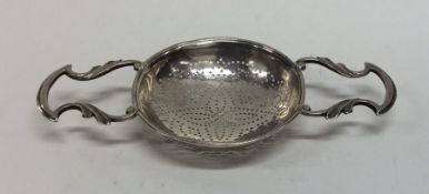 An early Georgian silver two handled lemon straine