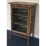 A bamboo mounted cabinet with fitted interior. Est