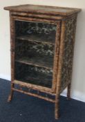 A bamboo mounted cabinet with fitted interior. Est