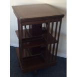 An Edwardian mahogany revolving bookcase decorated