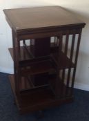 An Edwardian mahogany revolving bookcase decorated