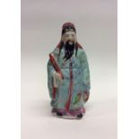 A Chinese figure of a man with blue ground shawl.