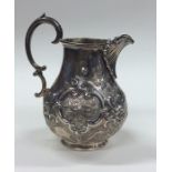 A good Victorian embossed silver cream jug decorat
