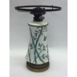 A Mintons pottery oil lamp on tapering supports. E