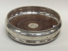 A modern silver wine coaster with bead decoration.