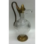 An Antique glass and brass mounted ewer on spreadi