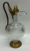 An Antique glass and brass mounted ewer on spreadi