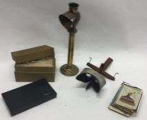 An old slide viewer together with slides and an old lacemaker's lamp.