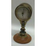 A small brass aneroid barometer on stand. Est. £30
