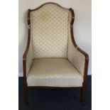 A late Victorian upholstered armchair on tapering
