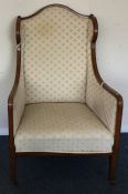 A late Victorian upholstered armchair on tapering
