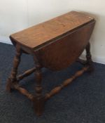 An oak two lap drop leaf table on spreading turned