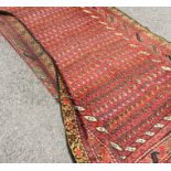 A long Antique Oriental rug decorated in bright co