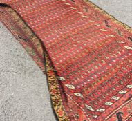 A long Antique Oriental rug decorated in bright co