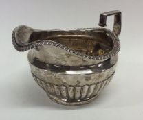 A heavy Georgian silver half fluted cream jug with