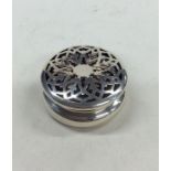 A small circular silver box with pierced decoratio