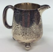 A Victorian silver cream jug decorated with flower