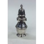 An Edwardian silver pepper with screw-on cover . L