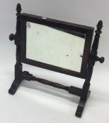 A small mahogany toilet mirror on turned supports.