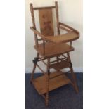 A small child's wooden high chair on turned suppor