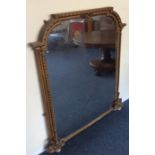 A gilt framed wall mirror with shaped top to carve