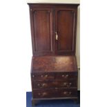 A Georgian oak bureau / bookcase on bracket feet t