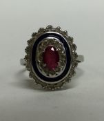 A ruby and enamelled cluster ring in 18 carat gold