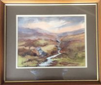 A framed and glazed watercolour depicting a landsc