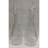 A pair of tall glass decanters on tapering bases w