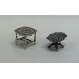 Two silver doll's house tables decorated with flowe