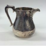 A Victorian engraved silver cream jug decorated wi