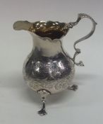 A Georgian silver engraved helmet shaped cream jug