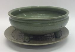 A massive celadon censer with spreading supports o