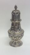 A large embossed silver sugar caster decorated wit