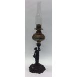 A tall porcelain mounted oil lamp on cast iron bas