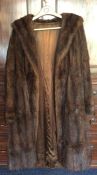 An old fur coat with silk lining. Est. £25 - £35.