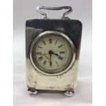 A silver miniature carriage clock with white ename