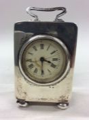 A silver miniature carriage clock with white ename