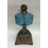 A blue glass mounted oil lamp with floral decorati