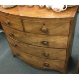 A mahogany bow front chest of five drawers on brac