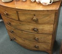 A mahogany bow front chest of five drawers on brac