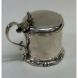 A Victorian hinged top mustard pot on scroll base.