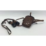 A pair of leather mounted Military binoculars. Est