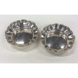 A pair of silver circular bonbon dishes with wavy