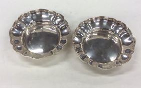 A pair of silver circular bonbon dishes with wavy