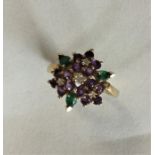 An 18 carat gold emerald, ruby and amethyst cluste