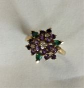 An 18 carat gold emerald, ruby and amethyst cluste