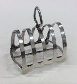 An Edwardian silver toast rack on bracket feet. Bi