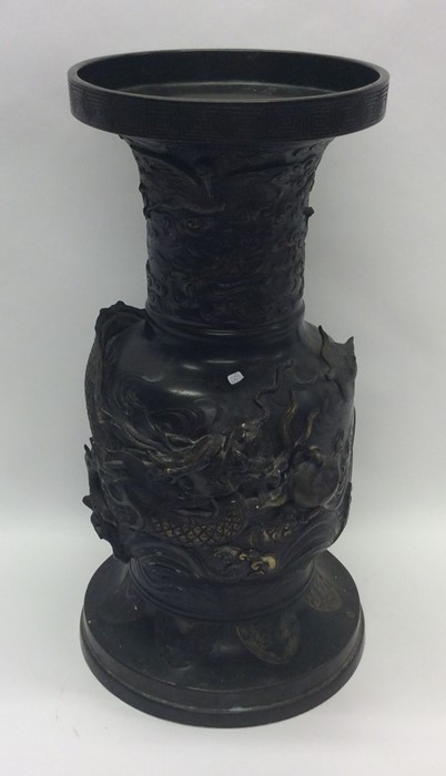 A tall bronze vase profusely decorated with dragon